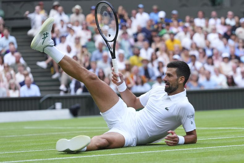 El serbio Novak Djokovic sentado en el césped tras responder a un tiro de su compatriota Miomir Kecmanovic en la tercera ronda de Wimbledon el sábado 5 de julio del 2025. (AP Foto/Kirsty Wigglesworth)