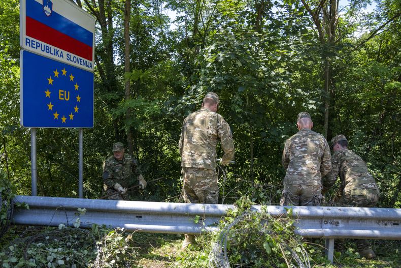 ARCHIVO - Soldados eslovenos retiran alambre con navajas en el cruce fronterizo con Croacia, en Krmacina, Eslovenia, el 15 de julio de 2022. (AP Foto/Darko Bandic, archivo)