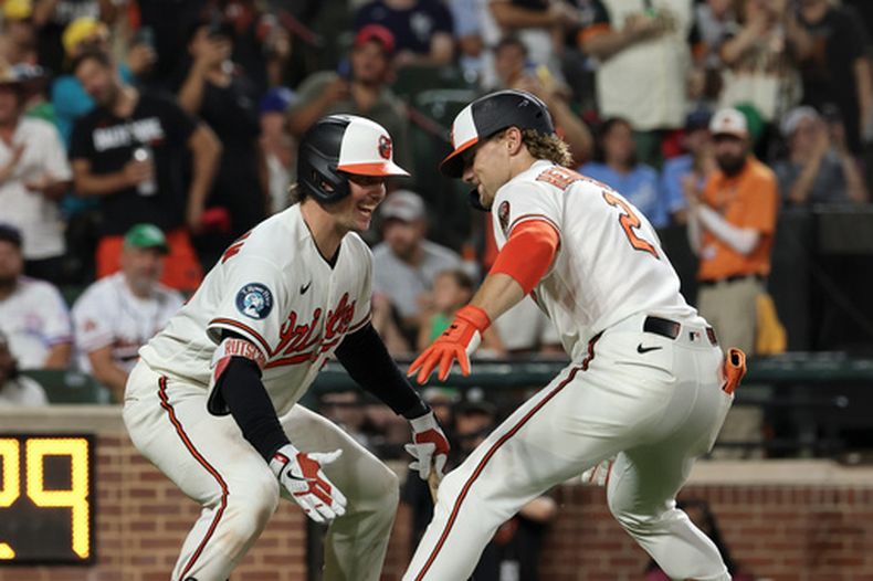 Gunnar Henderson (2), de los Orioles de Baltimore, celebra con Adley Rutschman, izquierda, después de batear un cuadrangular frente a Eli Morgan, de los Reales de Kansas City, durante la octava entrada del juego de béisbol de Grandes Ligas, el sábado 11 de julio de 2026, en Baltimore. (AP Foto/Terrance Williams)