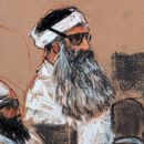 ARCHIVO - Este dibujo del lunes 8 de diciembre de 2008, realizado por la artista Janet Hamlin y revisado por las fuerzas armadas de Estados Unidos, muestra a Khalid Sheikh Mohammed, al centro, y a su cómplice Walid Bin Attash, izquierda, durante una sesión previa a un juicio en la Base Naval de Bahía de Guantánamo, Cuba. Khalid Sheikh Mohammed está acusado de ser el autor intelectual de los atentados del 11 de septiembre de 2001. (AP Foto/Janet Hamlin, foto compartida, archivo)