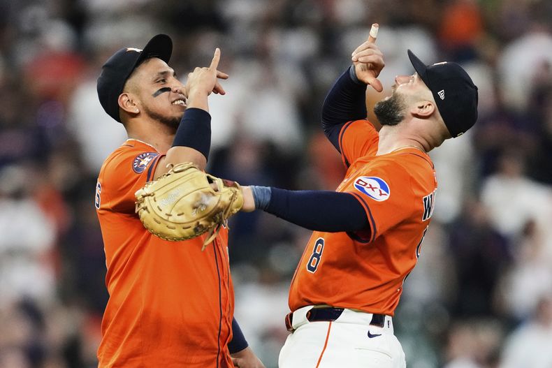 El tercera base Isaac Paredes, izquierda, y el primera base Christian Walker (8), de los Astros de Houston, celebran después de la victoria de su equipo en el juego de béisbol de Grandes Ligas sobre los Rojos de Cincinnati, el viernes 9 de mayo de 2025, en Houston. (AP Foto/Ashley Landis)