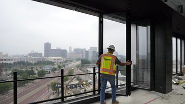 Un trabajador abre las ventanas del último piso del nuevo Hotel Godfrey, el 27 de junio de 2023, en Detroit. El 18 de julio de 2013, un administrador designado por el estado declaró a Detroit la ciudad más grande de EE.UU. en declararse en bancarrota. Una década después, la ciudad ha resurgido de entre las cenizas de la insolvencia. (AP Foto/Carlos Osorio)