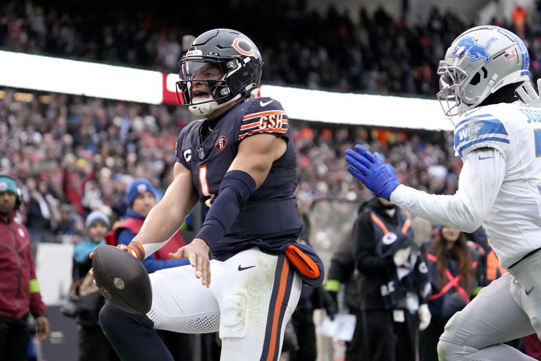 Justin Fields, quarterback de los Bears de Chicago, anota un touchdown por la vía terrestre, superando al safety Kerby Joseph, de los Lions de Detroit, durante la segunda mitad del juego de la NFL, el domingo 10 de diciembre de 2023. (AP Foto/Nam Y. Huh)