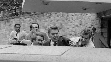 ARCHIVO - El presidente Ronald Reagan es empujado hacia su limusina por agentes del Servicio Secreto tras ser baleado el 30 de marzo de 1981, afuera de un hotel de Washington. (AP Foto/Ron Edmonds, archivo)