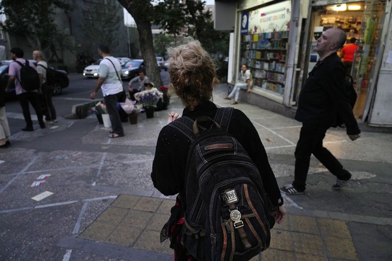 ARCHIVO - Una mujer iraní camina por el centro de Teherán, Irán, sin el velo obligatorio para cubrirse la cabeza, el 10 de junio de 2024. (AP Foto/Vahid Salemi, archivo)