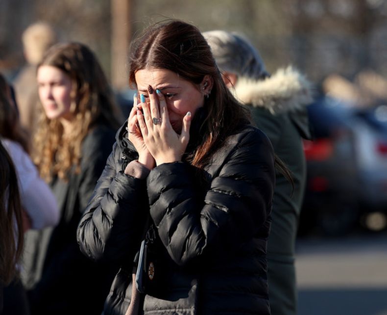 Una mujer se lamenta luego de un tiroteo en una pista de hielo, el lunes 16 de febrero de 2026, en Pawtucket, Rhode Island. (AP Foto/Mark Stockwell)