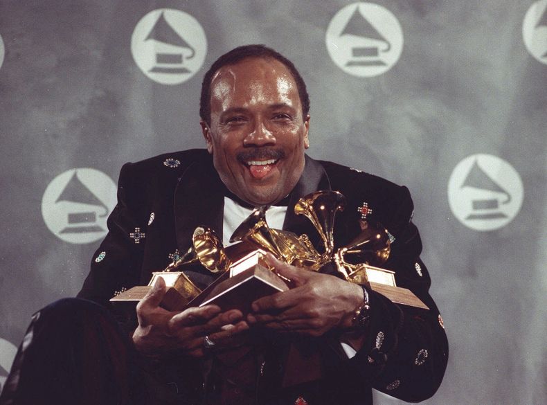 ARCHIVO - Quincy Jones sostiene sus premios Grammy, incluido el premio al álbum del año, por su ecléctico álbum Back on the Block durante la 33ª entrega anual de los premios Grammy, en el Radio City Music Hall de Nueva York la noche del 20 de febrero de 1991. Quincy Jones murió a los 91 años. (Foto AP/Susan Ragan, archivo)