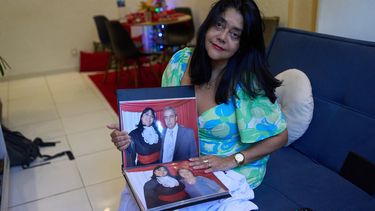 Simone Guimarães con una foto de ella y su esposo, quien murió de COVID, en su casa en Sao Goncalo, estado de Río de Janeiro, el 19 de noviembre del 2025. (AP foto/Silvia Izquierdo)