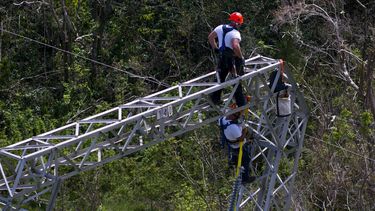 Trabajadores intentan restaurar el tendido eléctrico dañado por el paso del huracán María, el 15 de octubre de 2017, en Barceloneta, Puerto Rico. (AP Foto/Ramón Espinosa, archivo)