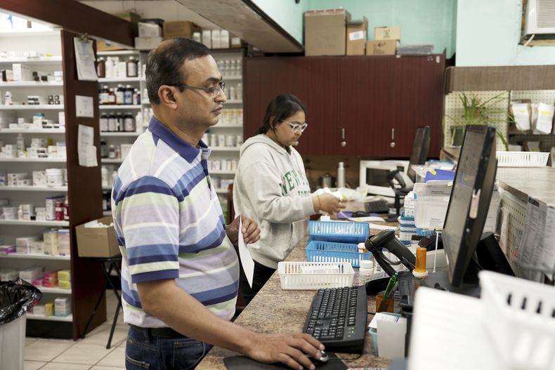 Prakash Patel (primer plano), dueño y farmaceuta, trabaja en Berts Pharmacy en Elizabeth, Nueva Jersey, el 21 de mayo de 2024. (AP Foto/Shelby Lum)