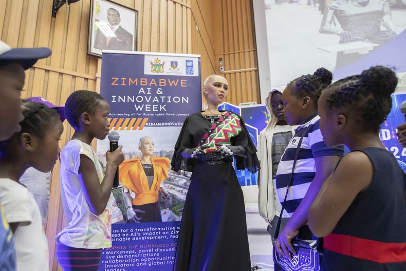 Sophia, el robot humanoide, responde preguntas de niños en la Universidad de Zimbabue, en Harare, el viernes 13 de diciembre de 2024. (AP Foto/Aaron Ufumeli)