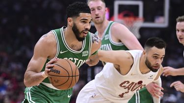 El alero de los Celtics de Boston Jayston Tatum (0) se dirige hacia el aro ante el base de los Cavaliers de Cleveland Max Strus (1) durante la primera mitad del Juego 4 de la serie de segunda ronda en los playoffs del baloncesto de la NBA, el lunes 13 de mayo de 2024, en Cleveland. (AP Foto/David Dermer)
