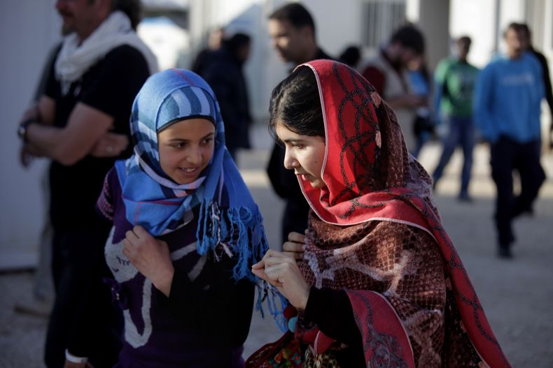 Malala Yousafzai, derecha, habla con Mzoun Mlihan, de 16 a&ntilde;os y refugiada siria, durante su visita al campamento de refugiados de Zaatari cerca de la frontera con Siria, en Mafraq, Jordania, el martes 18 de febrero del 2014. (Foto AP/Mohammad Hanno