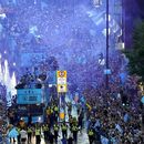 Jugadores del Manchester City recorren las calles de la ciudad en autobús descapotable para festejar con la afición tras ganar la tripleta de títulos el lunes 12 de junio del 2023. (Danny Lawson/PA via AP)