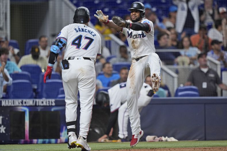 El venezolano Alí Sánchez, de los Marlins de Miami, felicita al dominicano Otto López, quien anotó en un elevado de Nick Gordon ante los Orioles de Baltimore, el miércoles 24 de julio de 2024 (AP Foto/Wilfredo Lee)