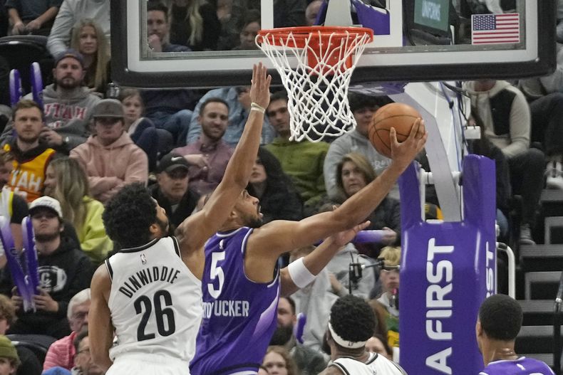 Talen Horton-Tucker, del Jazz de Utah, encesta frente a Spencer Dinwiddie, de los Nets de Brooklyn, durante el encuentro del lunes 18 de diciembre de 2023 (AP Roto/Rick Bowmer)