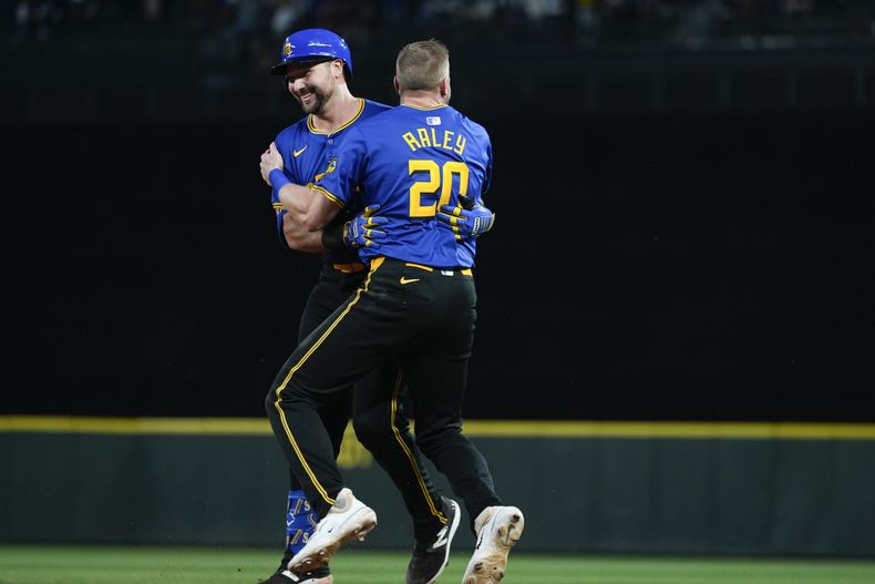 Cal Raleigh, izquierda, de los Marineros de Seattle, es felicitado por Luke Raley (20) después de batear una rola con la que impulsó la carrera de la victoria en la 10ma entrada en contra de los Mellizos de Minnesota, en el juego de béisbol del viernes 28 de junio de 2024, en Seattle. Los Marineros ganaron 3-2. (AP Foto/Lindsey Wasson)