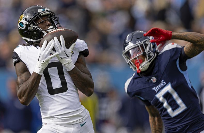 ARCHIVO - El wide receiver Calvin Ridley (0) atrapa un pase ante la cobertura del cornerback Sean Murphy-Bunting (0), de los Titans de Tennessee Titans, durante el partido de la NFL, el domingo 7 de enero de 2024, en Nashville, Tennessee. Ridley y los Titans de Tennessee llegaron a un acuerdo por cuatro años y 92 millones de dólares, dijo una persona con conocimiento del contrato a The Associated Press el miércoles 13 de marzo de 2024. (AP Foto/Wade Payne, Archivo)