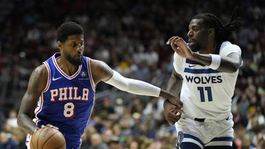 Paul George (8) de los 76ers de Filadelfia conduce el balón ante Naz Reid (11) de los Timberwolves de Minnesota, el viernes 11 de octubre de 2024, en Des Moines, Iowa. (AP Foto/Charlie Neibergall)