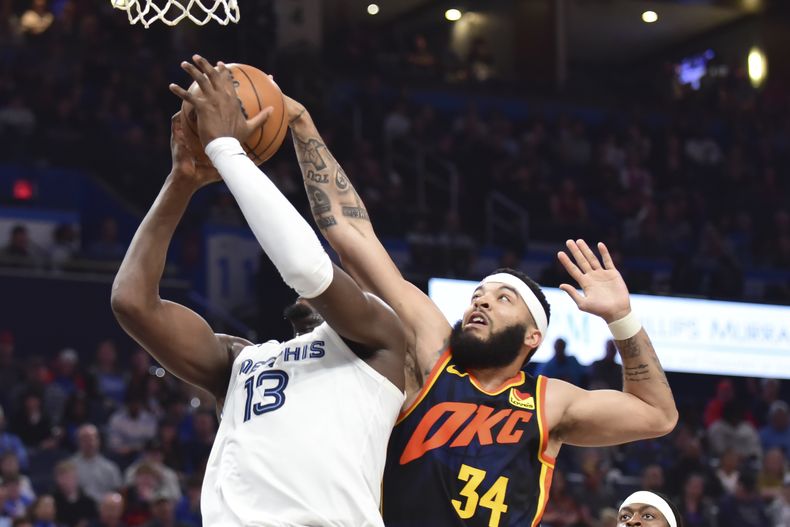 Kenrich Williams (34), del Thunder de Oklahoma City, bloquea un intento de retacada de Jaren Jackson Jr. (13), de los Grizzlies de Memphis, en la segunda mitad del juego de baloncesto de la NBA, el domingo 10 de marzo de 2024, en Oklahoma City. (AP Foto/Kyle Phillips)