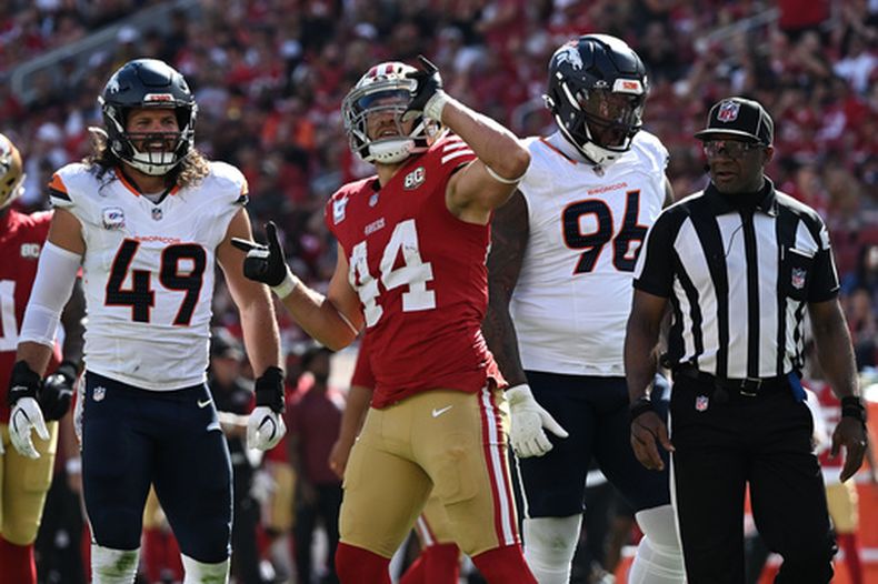 El fullback de los 49ers de San Francisco Kyle Juszczyk hace un gesto en celebración al convertir un primer down junto al lineback de los Broncos de Denver Alex Singleton y el defensive tackle Eyioma Uwazurike en el encuentro del domingo 4 de octubre del 2026. (AP Foto/Justine Willard)
