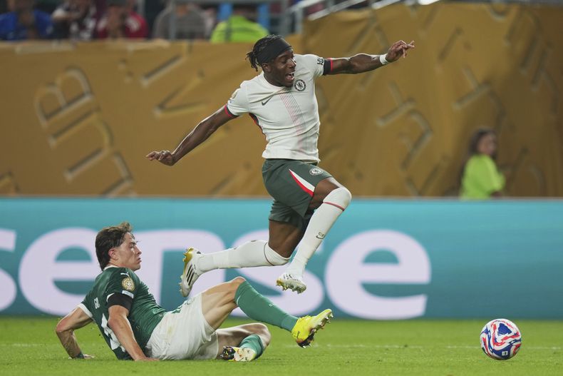 Noni Madueke (derecha) de Chelsea salta sobre Agustin Giay de Palmeiras en los cuartos de final del Mundial de Clubes, el viernes 4 de julio de 2025. (AP Foto/Chris Szagola)