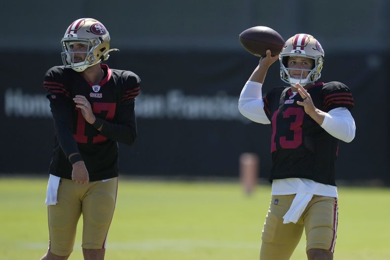 Los mariscales de campo de los 49ers de San Francisco, Brandon Allen (17) y Brock Purdy (13), lanzan pases durante el campamento de entrenamiento de fútbol americano de la NFL en Santa Clara, California, el miércoles 31 de julio de 2024. (AP Foto/Jeff Chiu)