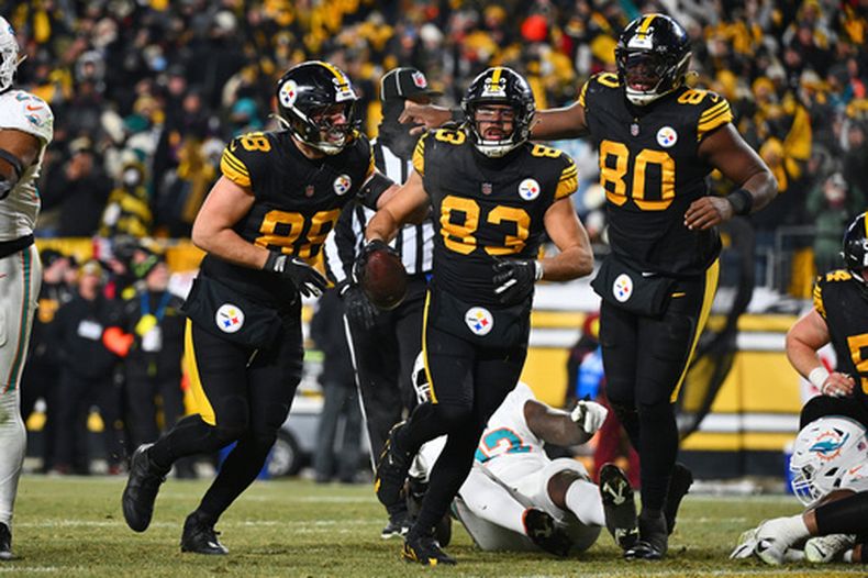 Pat Freiermuth (88), Connor Heyward (83) y Darnell Washington (80) celebran la anotación terrestre de Heyward en la primera mitad de un juego de fútbol americano de la NFL contra los Dolphins de Miami en Pittsburgh, el lunes 15 de diciembre de 2025. (AP Photo/Justin Berl)