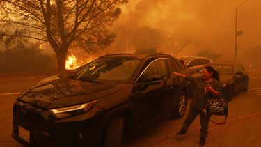 Una mujer llora mientras el incendio de Palisades avanza en el barrio de Pacific Palisades de Los Ángeles, el martes 7 de enero de 2025. (AP foto/Etienne Laurent)