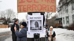Varias personas se congregan en torno a un monumento de recuerdo improvisado para la víctima de un tiroteo letal con agentes de seguridad, cerca del lugar de los hechos, el 8 de enero de 2026, en Minneapolis. (AP Foto/Tom Baker)