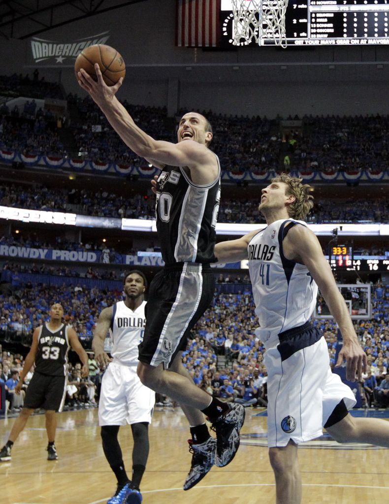 El argentino Manu Gin&oacute;bili, de los Spurs de San Antonio, salta para encestar frente al alem&aacute;n Dirk Nowitzki, de los Mavericks de Dallas, en el duelo de postemporada realizado el lunes 28 de abril de 2014 (AP Foto/Tony Guti&eacute;rrez)