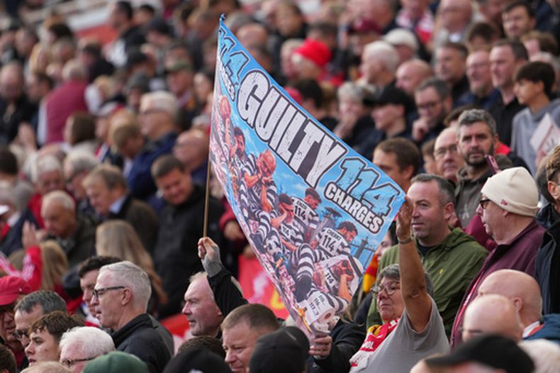 Aficionados del Liverpool sostiene un cartel antes del encuentro ante el Manchester City en la Liga Premier en relación al escándalo de irregularidades financieras el domingo 11 de octubre del 2026. (AP Foto/Jon Super)