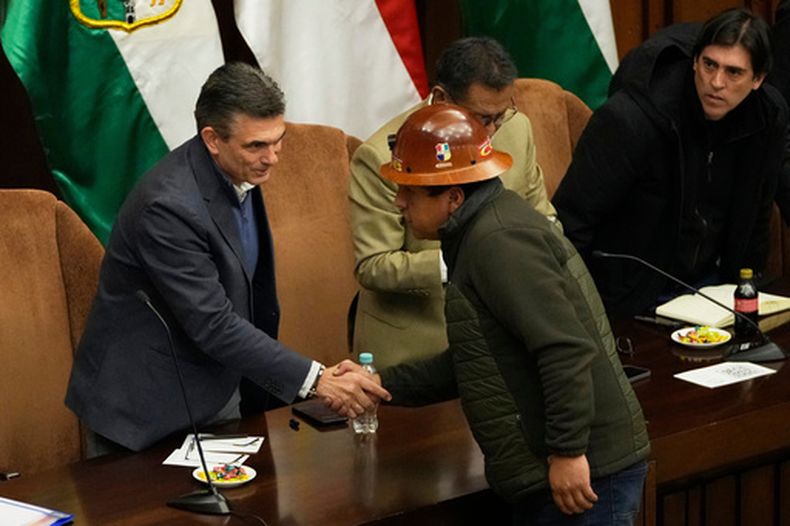 El presidente boliviano Rodrigo Paz, a la izquierda, estrecha la mano de Mario Argollo, líder de la Central Obrera Boliviana (COB), en La Paz, Bolivia, el miércoles 17 de junio de 2026, tras semanas de protestas y bloqueos de carreteras en todo el país. (AP Foto/Juan Karita)