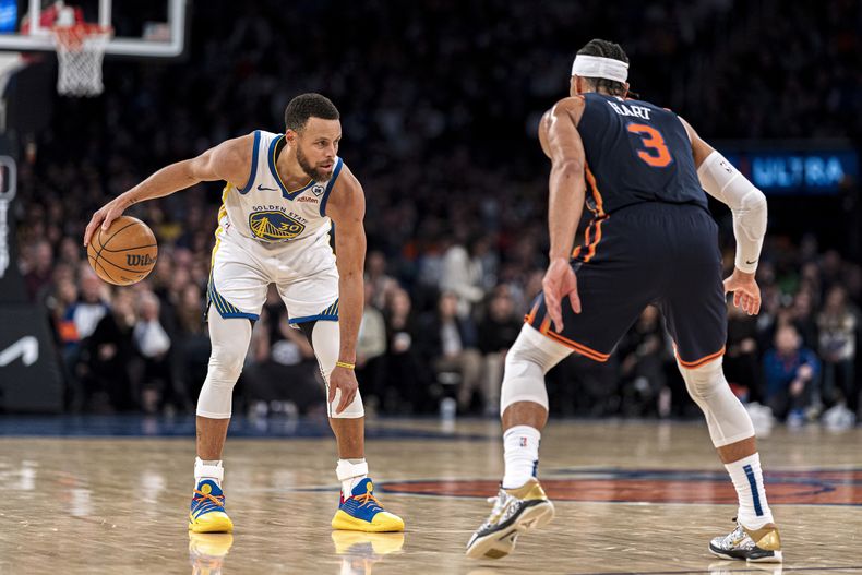 El escolta de los Knicks de Nueva York, Josh Hart (3), defiende contra el escolta de los Warriors de Golden State, Stephen Curry (30), durante la segunda mitad del partido de baloncesto de la NBA en Nueva York, el jueves 29 de febrero de 2024. (AP Foto/Peter K. Afriyie)