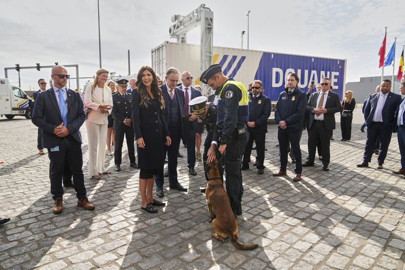 La secretaria de Seguridad Nacional de Estados Unidos, Kristi Noem saluda a una perra que detecta mercancías prohibidas, llamada Emma, durante una visita al puerto de Amberes, Bélgica, el miércoles 10 de septiembre de 2025. (AP Foto/Virginia Mayo)