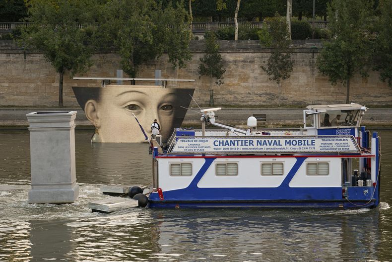Un bote pasa junto a una reproducción artística en el río Sena durante los Juegos Olímpicos el martes 30 de julio del 2024. (AP Foto/Vadim Ghirda)