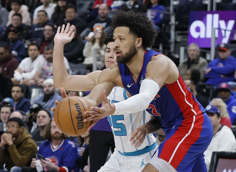 El escolta de los Pistons de Detroit, Cade Cunningham, a la derecha, agarra el balón contra el escolta de los Hornets de Charlotte, KJ Simpson, a la izquierda, durante la primera mitad de un partido de baloncesto de la NBA, el domingo 9 de febrero de 2025, en Detroit. (AP Foto/Duane Burleson)