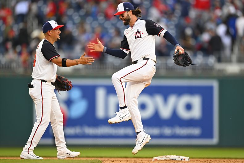 El tercera base venezolano de los Nacionales de Washington Ildemaro Vargas (izquierda) celebra junto a su compañero de equipo, el jardinero Jesse Winker, luego de vencer a los Azulejos de Toronto, el domingo 5 de mayo de 2024, en Washington. (AP Foto/John McDonnell)