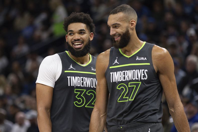 Karl-Anthony Towns (32) y Rudy Gobert, de los Timberwolves de Minnesota, sonríen durante el partido del miércoles 31 de enero de 2024, ante los Mavericks de Dallas (AP Foto/Bailey Hillesheim)