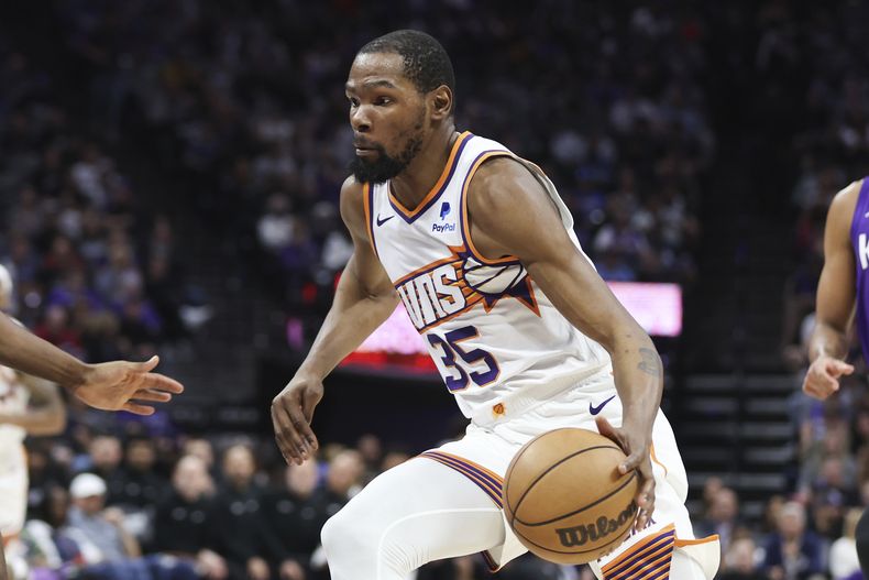Kevin Durant, alero de los Suns de Phoenix, avanza con el balón en el duelo ante los Kings de Sacramento, el viernes 12 de abril de 2024 (AP foto/Benjamin Fanjoy)