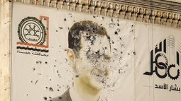 Una imagen del presidente sirio, Bashar Assad, marcada por disparos, en la oficina del gobierno provincial tras la toma de Hama por parte de la oposición, en Siria, el viernes 6 de diciembre de 2024. (AP Foto/Omar Albam)