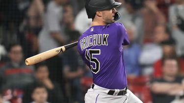 Randal Grichuk, de los Rockies de Colorado, conecta un doble de dos carreras en la décima entrada del juego ante los Medias Rojas de Boston, el martes 13 de junio de 2023 (AP Foto/Charles Krupa)