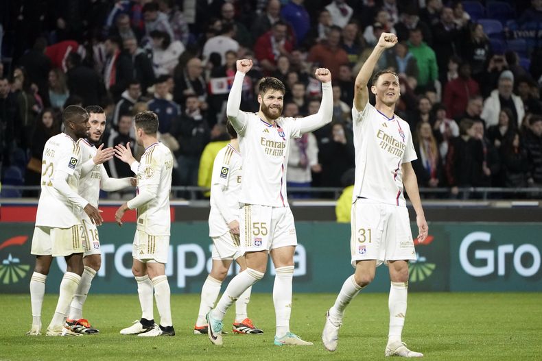Jugadores de Lyon celebran después de ganar en la Liga de Francia el partido de fútbol entre Lyon y Niza en el estadio Groupama, a las afueras de Lyon, Francia, el viernes 16 de febrero de 2024. (AP Foto/Laurent Cipriani)