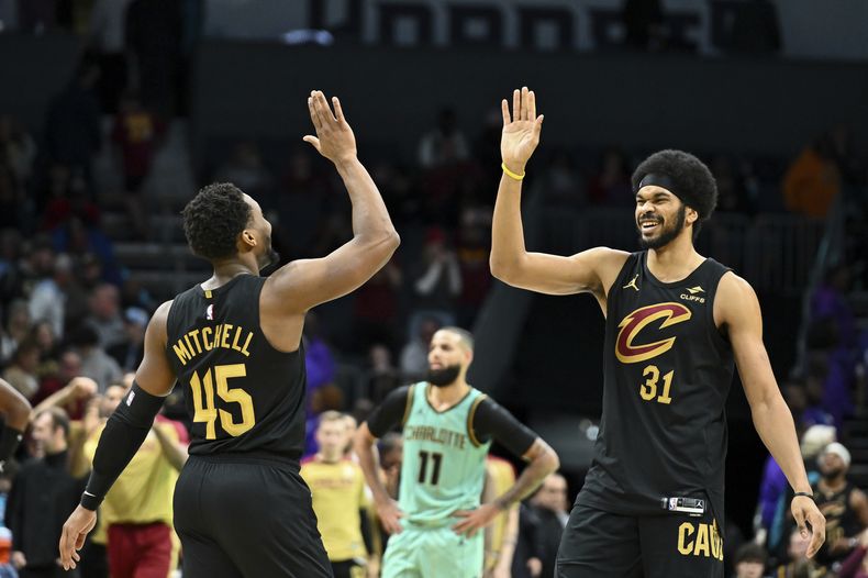 El pivot de los Cavaliers de Cleveland Jarrett Allen y el base Donovan Mitchell (45) se dan los cinco en el encuentro ante los Hornets de Charlotte el sábado 7 de diciembre del 2024. (AP Foto/Matt Kelley)