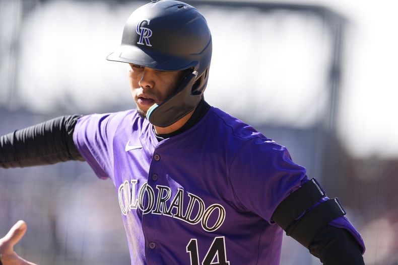El venezolano de los Rockies de Colorado Ezequiel Tovar es felicitado luego de impulsar la carrera del empate en la 10ma entrada del primero de dos juegos de béisbol ante los Marineros de Seattle, el domingo 21 de abril de 2024, en Denver. (AP Foto/David Zalubowski)