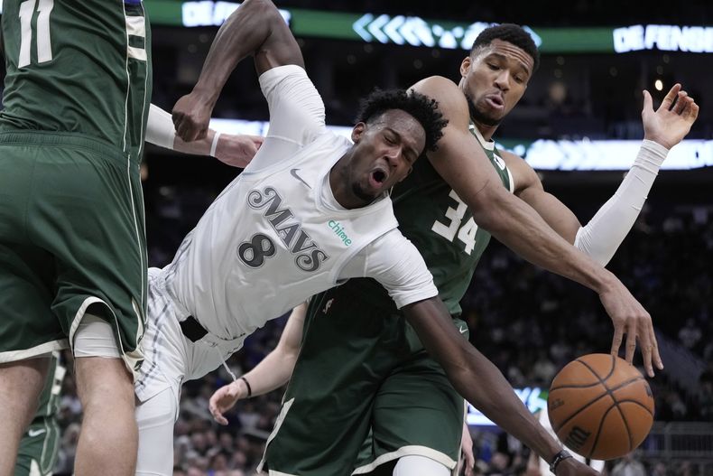 Giannis Antetokounmpo, de los Bucks de Milwaukee, comete una falta sobre Olivier-Maxence Prosper, de los Mavericks de Dallas, durante la primera mitad de un partido de baloncesto de la NBA, el miércoles 5 de marzo de 2025, en Milwaukee. (AP Foto/Morry Gash)