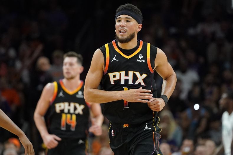 Devin Booker, de los Suns de Phoenix, sonríe luego de encestar ante los Timberwolves de Minnesota, en el partido del miércoles 15 de noviembre de 2023 (AP Foto/Matt York)