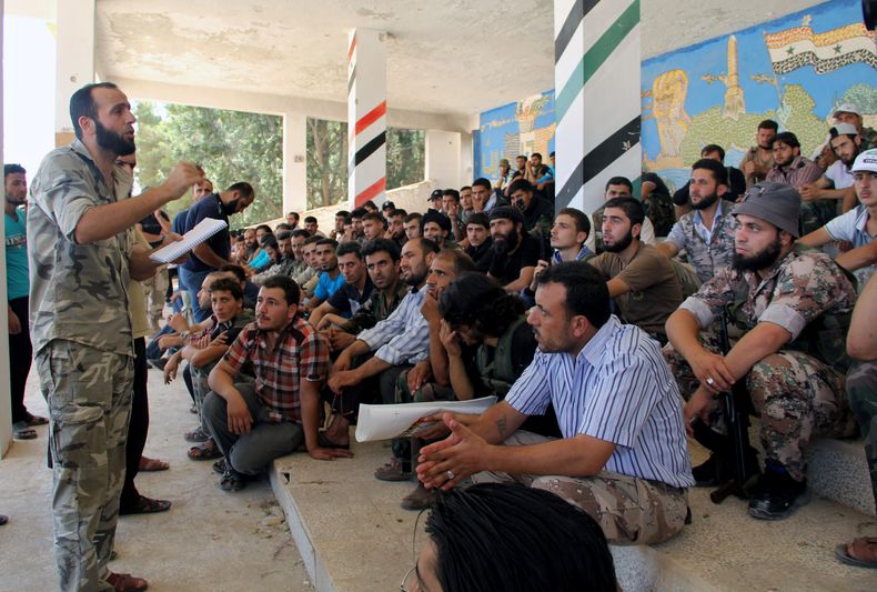 En esta imagen de periodismo ciudadano del martes 13 de agosto de 2013 cedida por la Brigada Tawhid, que ha sido autentificada por su contenido e investigaciones de la AP, Abdul-Qadir Saleh (izquierda), jefe de la Brigada Tawhid, el principal grupo rebeld