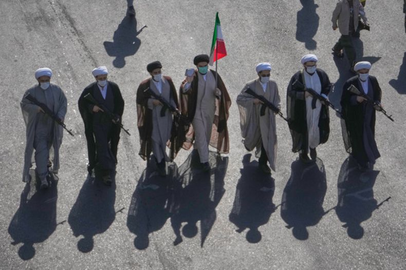 Clérigos chiíes cargan fusiles durante el desfile militar titulado Janfada o Sacrificio por Irán en la plaza de la Revolución en Teherán, Irán, el viernes 18 de septiembre de 2026. (AP Foto/Vahid Salemi)