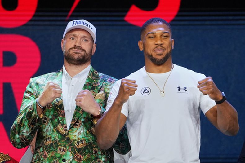 Tyson Fury y Anthony Joshua posan tras una conferencia en Londres, el miércoles 30 de septiembre de 2026 para promover su próxima pelea (AP Foto/Kin Cheung)